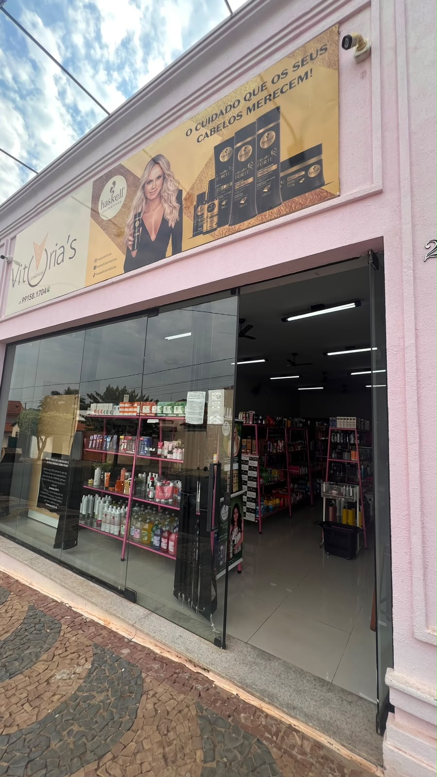 Fachada da loja Vitória's Faria Cosméticos, com vitrine de vidro e prateleiras organizadas
